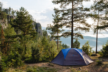 A place to sleep in a tent camping in the forest, setting up a tent in the mountains, a gray awning from the rain, trekking in the highlands, hiking in the mountains.