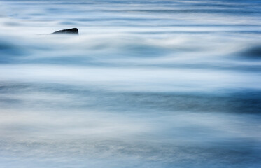 Flowing Blurry River Water Because of the Long Exposure. Background. Stones in background.