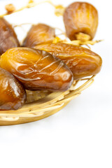 Close-up of Algerian royal dates on a wooden plate on a white background. Ramadan concept.