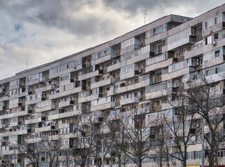 Worn out apartment building from the communist era against blue sky in Bucharest Romania. Ugly traditional communist housing ensemble