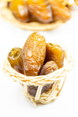 Close-up of Algerian royal dates on a wooden plate on a white background. Ramadan concept.
