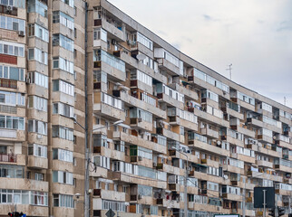 Worn out apartment building from the communist era against blue sky in Bucharest Romania. Ugly...