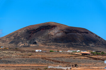 Vista panorámica de un paisaje desértico con una gran montaña detrás en las Islas Canarias de...
