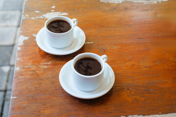 Two sturdy Americanos in white mugs side view. Black coffee for two for breakfast