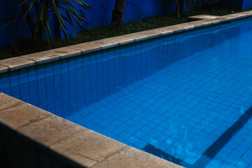 Swimming pool with clear blue water against the background of the wall. Relax in a hotel by the water