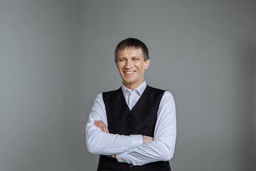 Male portrait in a classic shirt and vest on a gray background