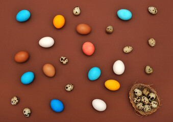 Easter concept painted and quail eggs on a terracotta background