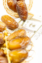 Close-up of Algerian royal dates on a wooden plate. Saudi Arabia Money Banknotes. Ramadan concept.