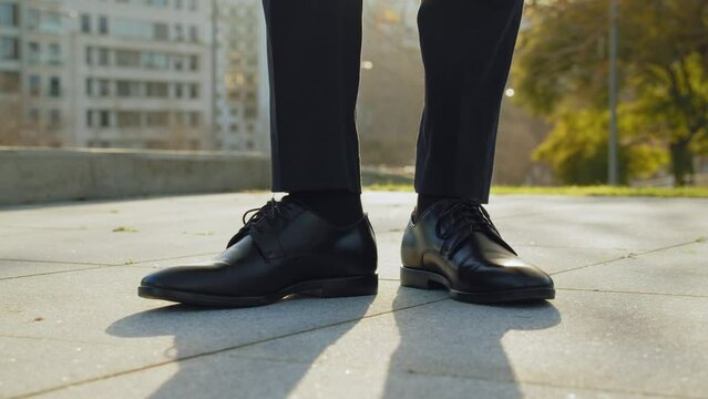 Businessman walk into the frame black new shoes. Legs of a businessman in fashionable shoes. Business concept. Stylish men wears. Low angle.