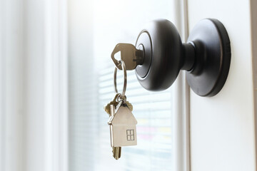 House keys hanging from a doorknob of a new home that is being sold by a realtor.