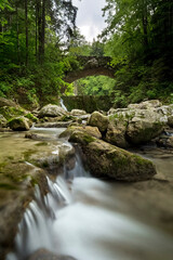 Naklejka na ściany i meble The Astico stream and the ancient stone bridge along the nature trail 