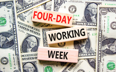 Four-day working week symbol. Concept words Four-day working week on wooden block on a beautiful background from dollar bills. Dollar bills. Business four-day working week concept. Copy space.