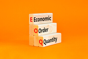 Naklejka premium EOQ economic order quantity symbol. Concept words EOQ economic order quantity on wooden blocks on a beautiful orange table orange background. Business EOQ economic order quantity concept. Copy space.
