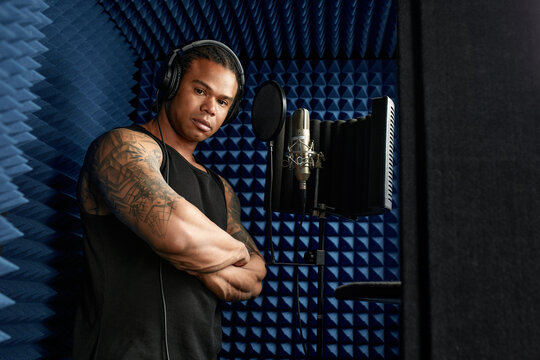 African American at the recording studio in headphones reads rap