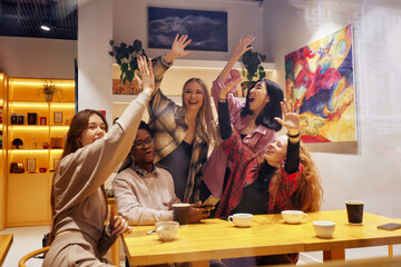 A company of young people in a cafe, have fun, drink coffee, have fun browsing social networks with a cheerful company, modern young people with laptops and smartphones