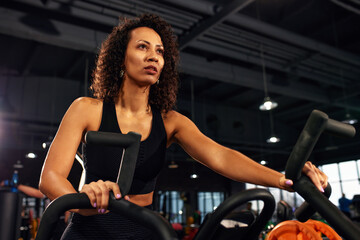Plakat african american woman cardio slimming aerobics training on bicycle