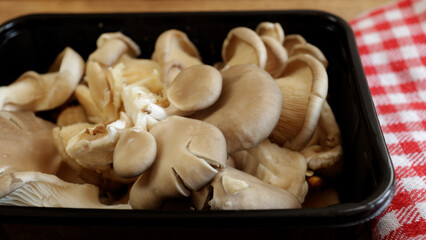 barquette de champignons pleurotes, en gros plan, sur une table