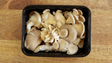 barquette de champignons pleurotes, en gros plan, sur une table