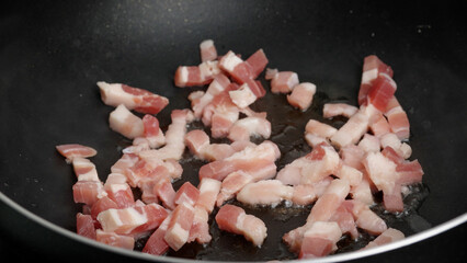lardons de porc cuit dans une poêle en gros plan