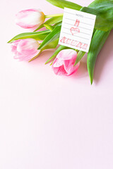 Fototapeta premium Bouquet of pink tulips on pink background. Greeting card for mother's day, women's day March 8. Celebration of spring holidays. Flat lay from flowers, top view, copy space. 