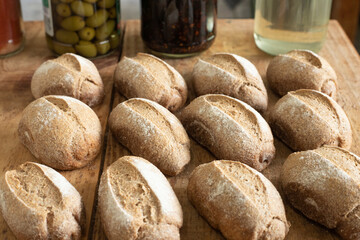 Obraz premium Deliciosos pãesinhos rústicos caseiros, feitos com farinha de trigo integral. Apresenta um realce no sabor e crocância na casca de cor dourada, com aroma irresistível que atraem os amantes de pão.