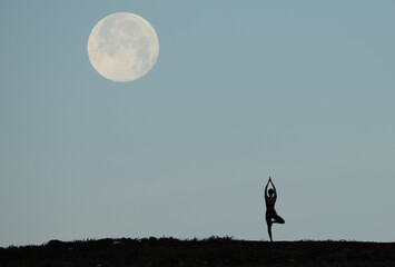 silhouette of a person with the moon and yoga
