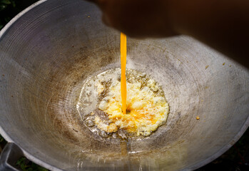 Close-up original and tradition Thai style scramble eggs in wok full of oil, One of commonly known as fast food of the people