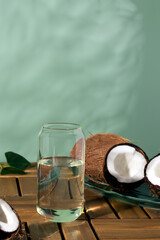 Coconut water into a glass on a green background