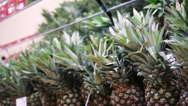 Frames of containers with ripe pineapple fruits in the food passage in the supermarket. Natural fruits for a healthy diet. The concept of a healthy diet.