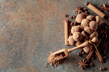 Chocolate truffles and spoon with cocoa powder.