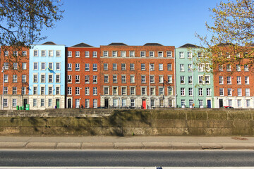 Cityscape of Dublin with blue sky in the background. Colorful houses along the river Liffey