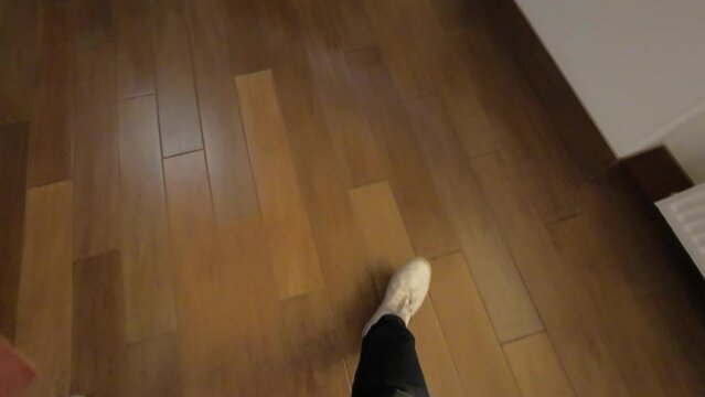 Young couple exit elevator. Doors open, POV legs in white sneakers