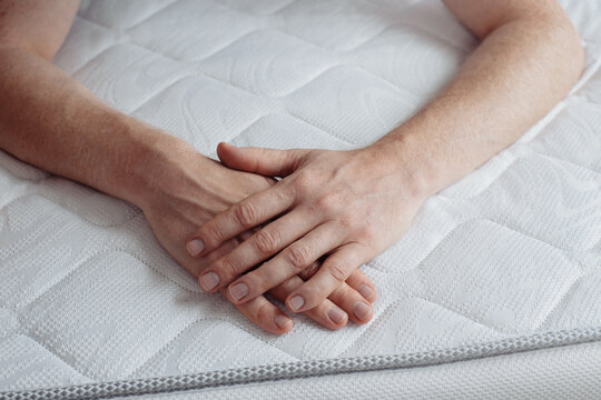 hand lies on a white blanket, advertising photo