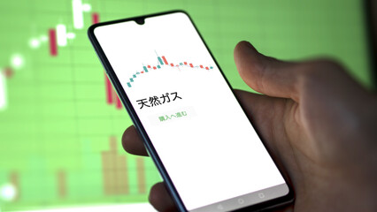 An investor analysing an ETF on a screen. Funds stocks exchange with Japanese text: Natural gas, buy