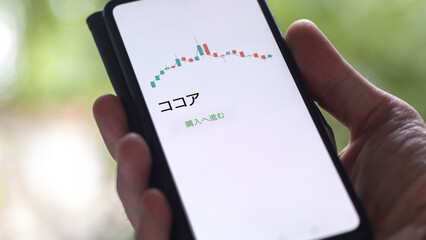 An investor analysing an ETF on a screen. Funds stocks exchange with Japanese text: cocoa, buy
