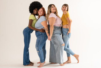 Obraz premium Multiracial group of women holding hands and looking at camera. Group of young women smiling and joking together at studio