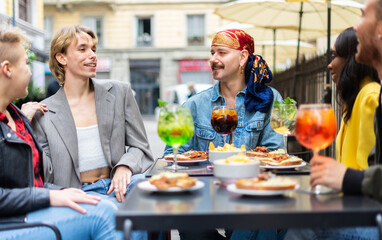 Friends relaxing at pub after work with cocktails drinks and food - Concept of party people