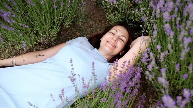 Harmony with nature. beautiful girl lies on a field of blooming lavender. happy girl inhales the fragrance of beautiful flowers.