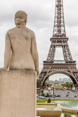 Statue of a woman on the background of the Eiffel Tower in Paris