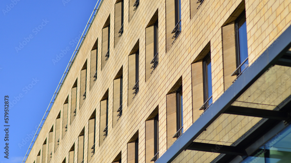 Wall mural Detail of a modern yellow brick building with large windows.