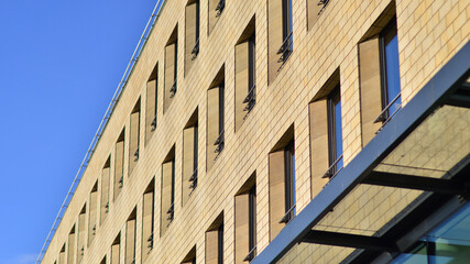 Detail of a modern yellow brick building with large windows.