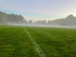 A foggy football field, Low angle of the green grass of a football field. Concept of a sports field