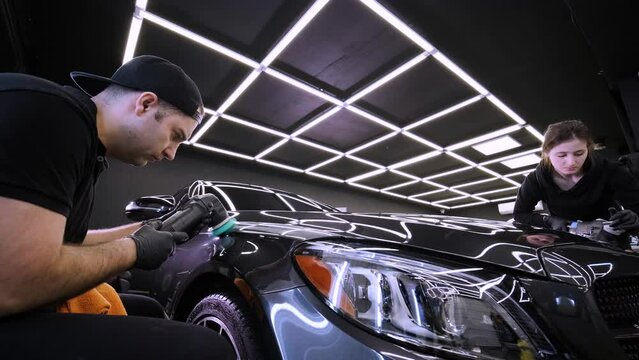 Professional car detailing using machinery and polishers for paint restoration.