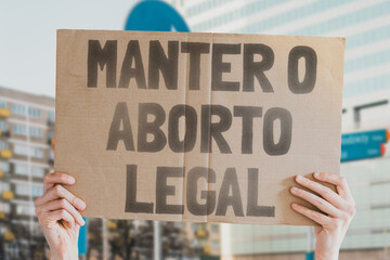 The phrase " Keep abortion legal " is drawn on a piece of paper in a woman's hands. A Caucasian woman with light hair holds a cardboard with an inscription. Human Rights. Freedom. Choice