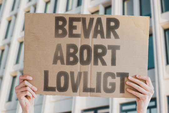 The phrase " Keep abortion legal " is drawn on a piece of paper in a woman's hands. A Caucasian woman with light hair holds a cardboard with an inscription. Human Rights. Freedom. Choice