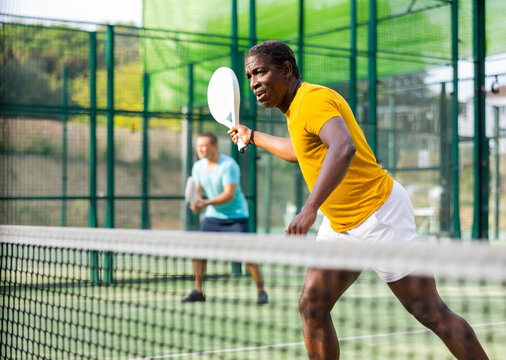 Portrait of an african american padel tennis player playing during a friendly doubles match on the outdoor court