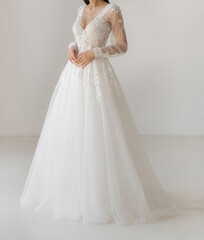 Gorgeous long white wedding dress with transparent sleeves and floral lace. The bride dressed in a...