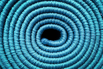 Rolled carpet, texture of a spiral carpet in blue, close-up