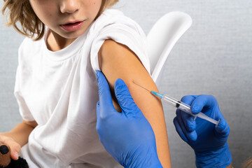 vaccination of children, a little boy at a doctor's appointment, an injection in the arm, children's medicine, an injection in the arm - obrazy, fototapety, plakaty