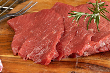  plusieurs steaks de bœuf crus, en gros plan, sur une planche à découper